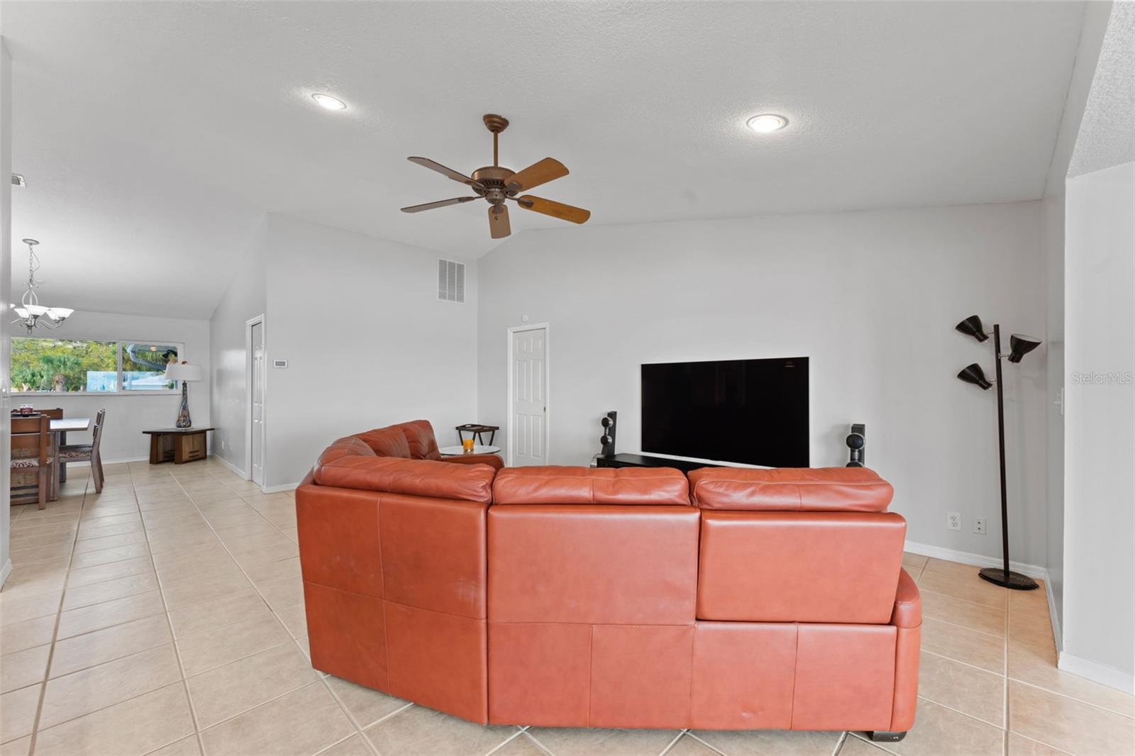 Spacious family room featuring vaulted ceilings and recessed lighting for an open, airy feel.