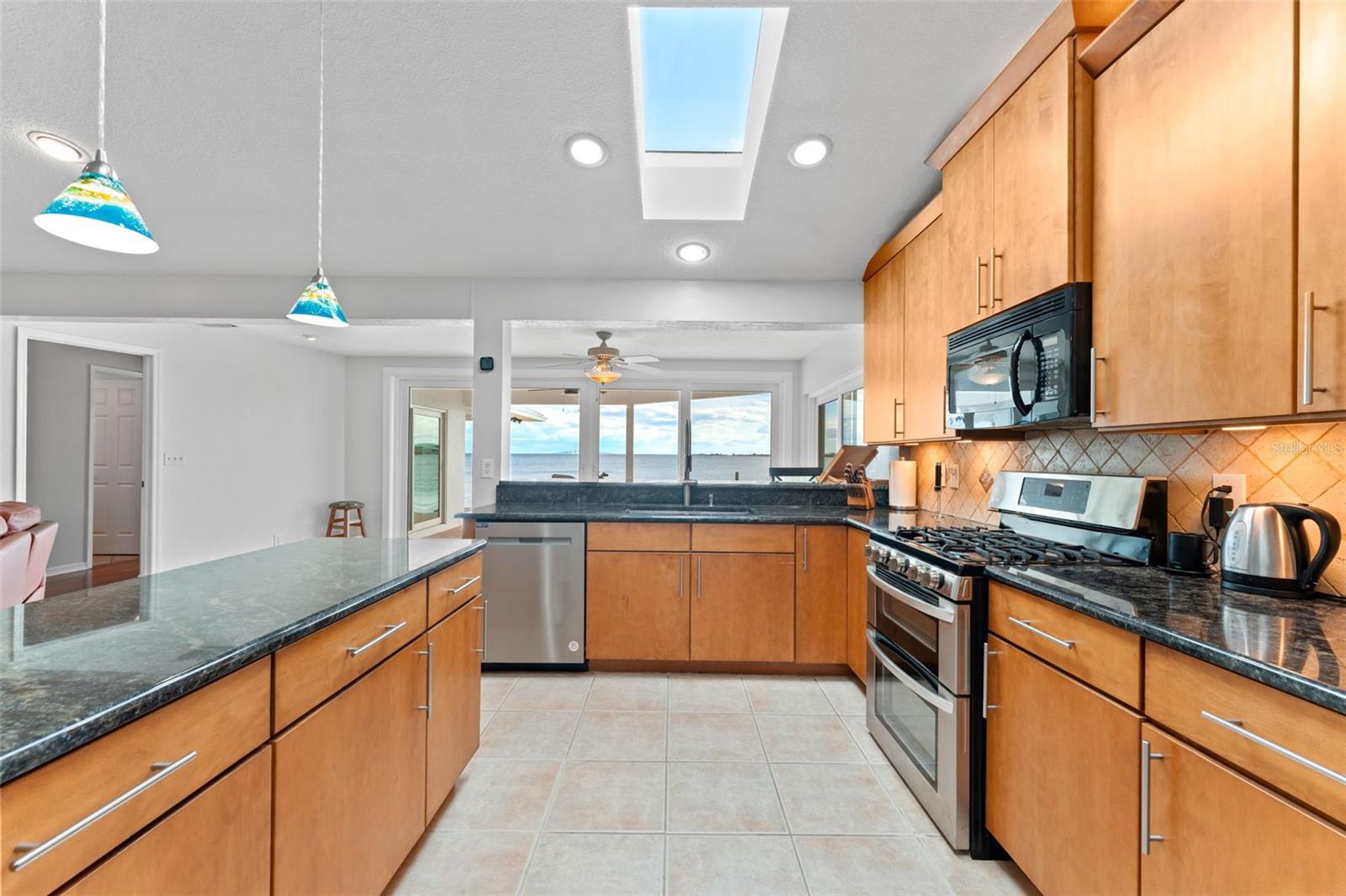 Enjoy abundant natural light and serene water views while cooking or dining in this bright, airy kitchen.