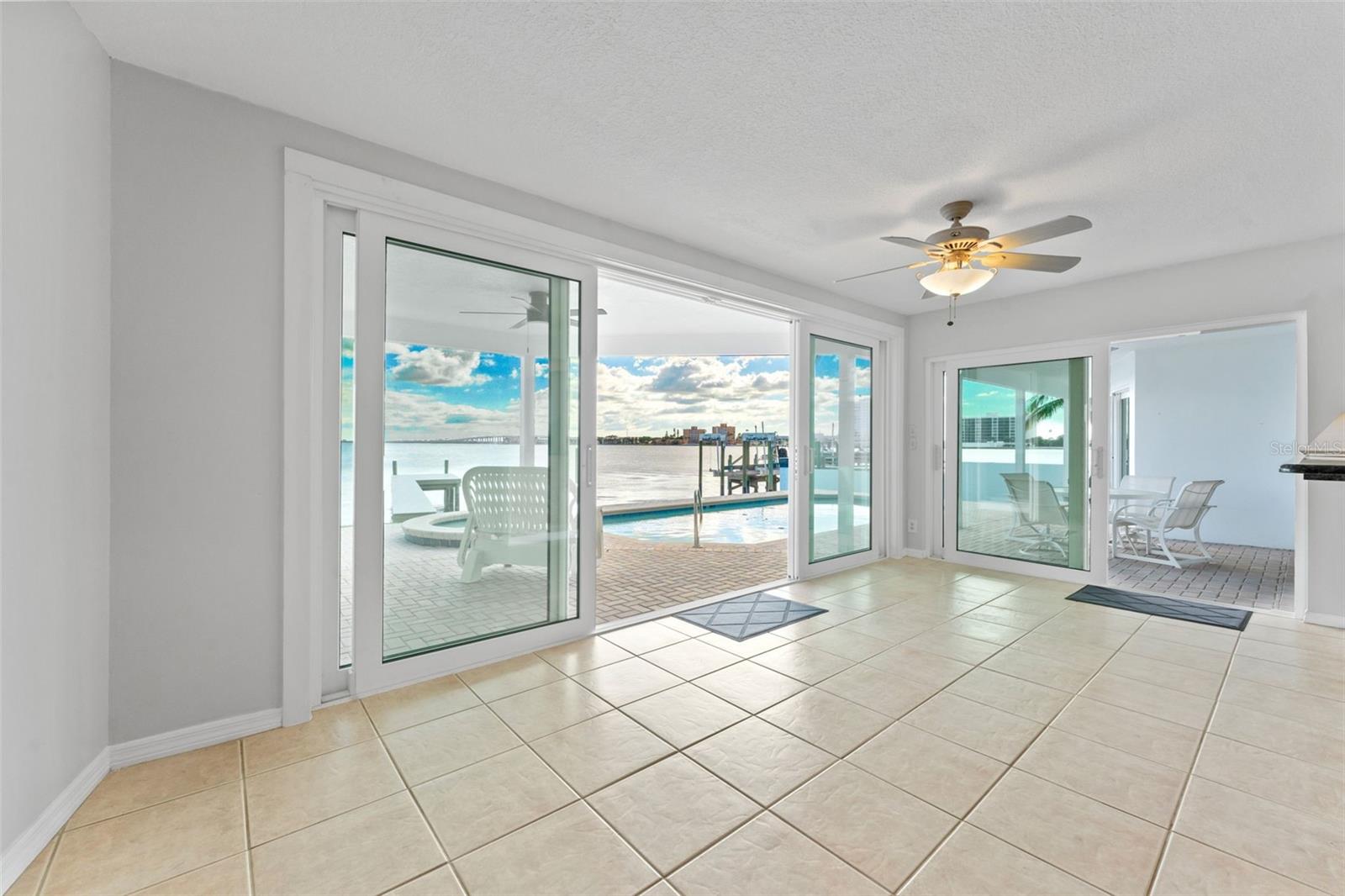 Bright breakfast nook/bonus room with impact-rated sliding glass doors opens to the pool deck and stunning waterfront views.