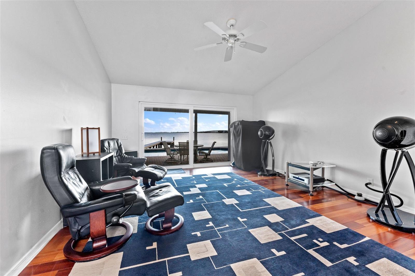 Elegant formal living room featuring sliding glass doors that frame serene water views and fill the space with natural light.