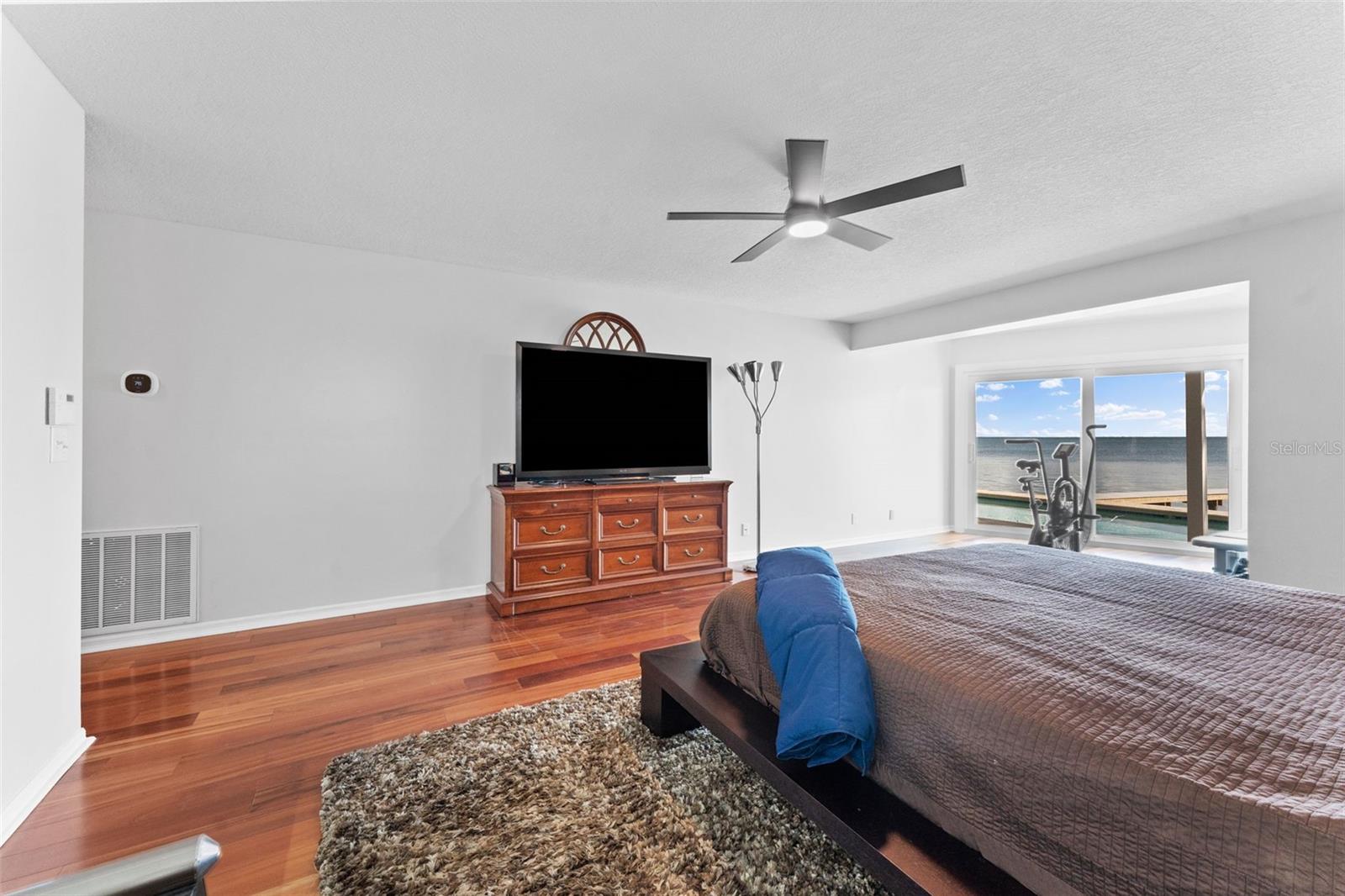 Spacious primary bedroom with hardwood flooring, offering plenty of room for all your furniture and personal touches.