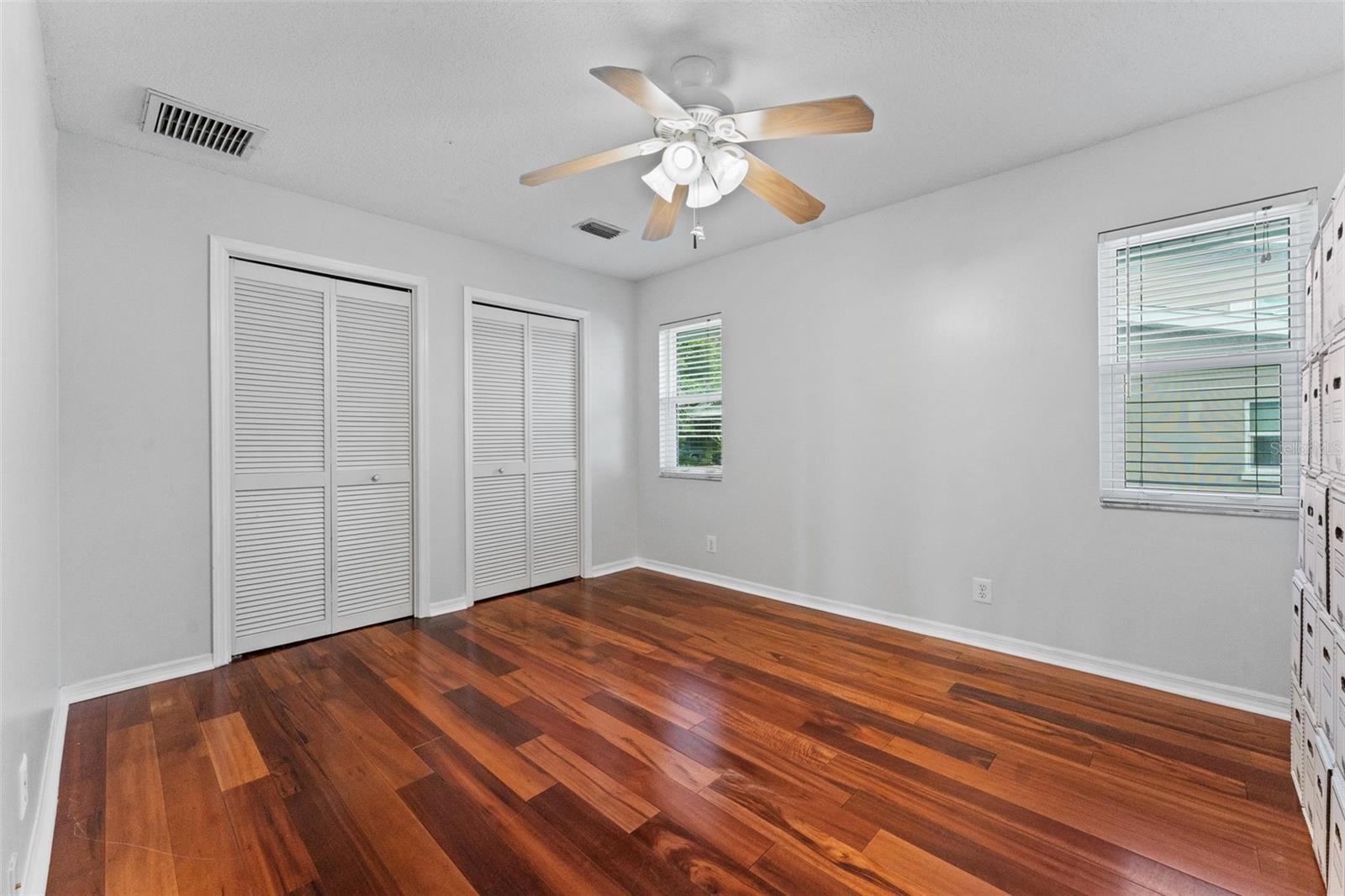 Bedroom 3 with hardwood floors and a spacious built-in closet, offering plenty of storage and comfort.