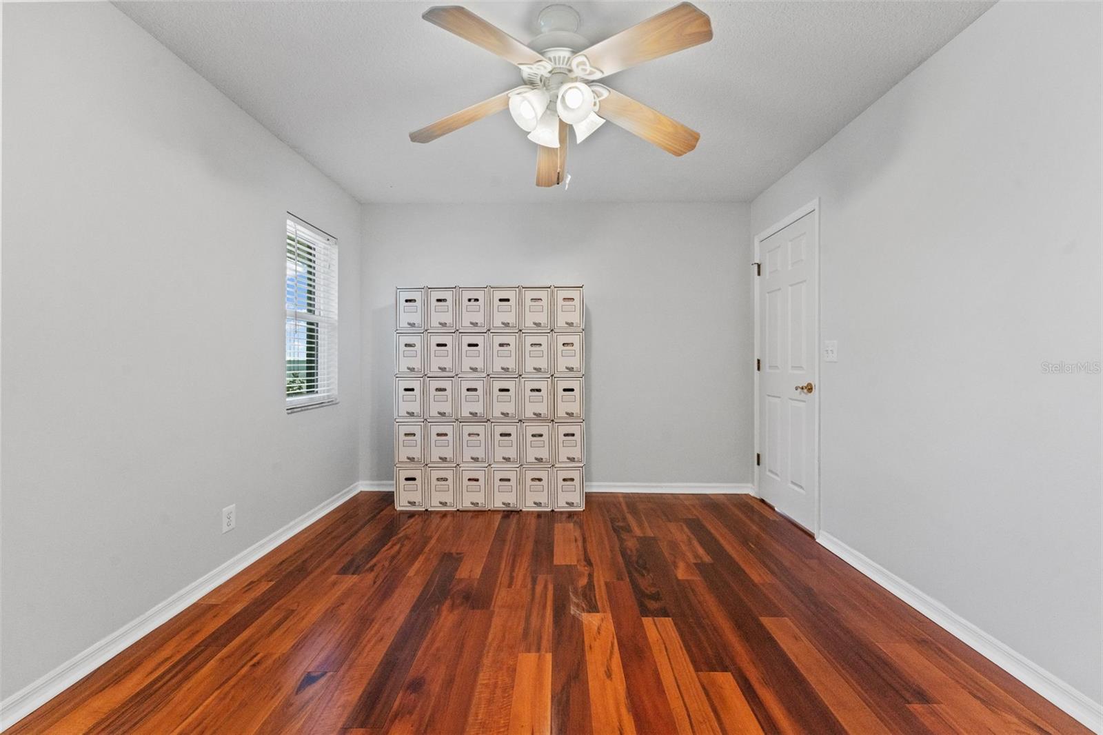 Bright and inviting Bedroom 3 with hardwood floors and ample closet space, ideal for family, guests, or a home office.