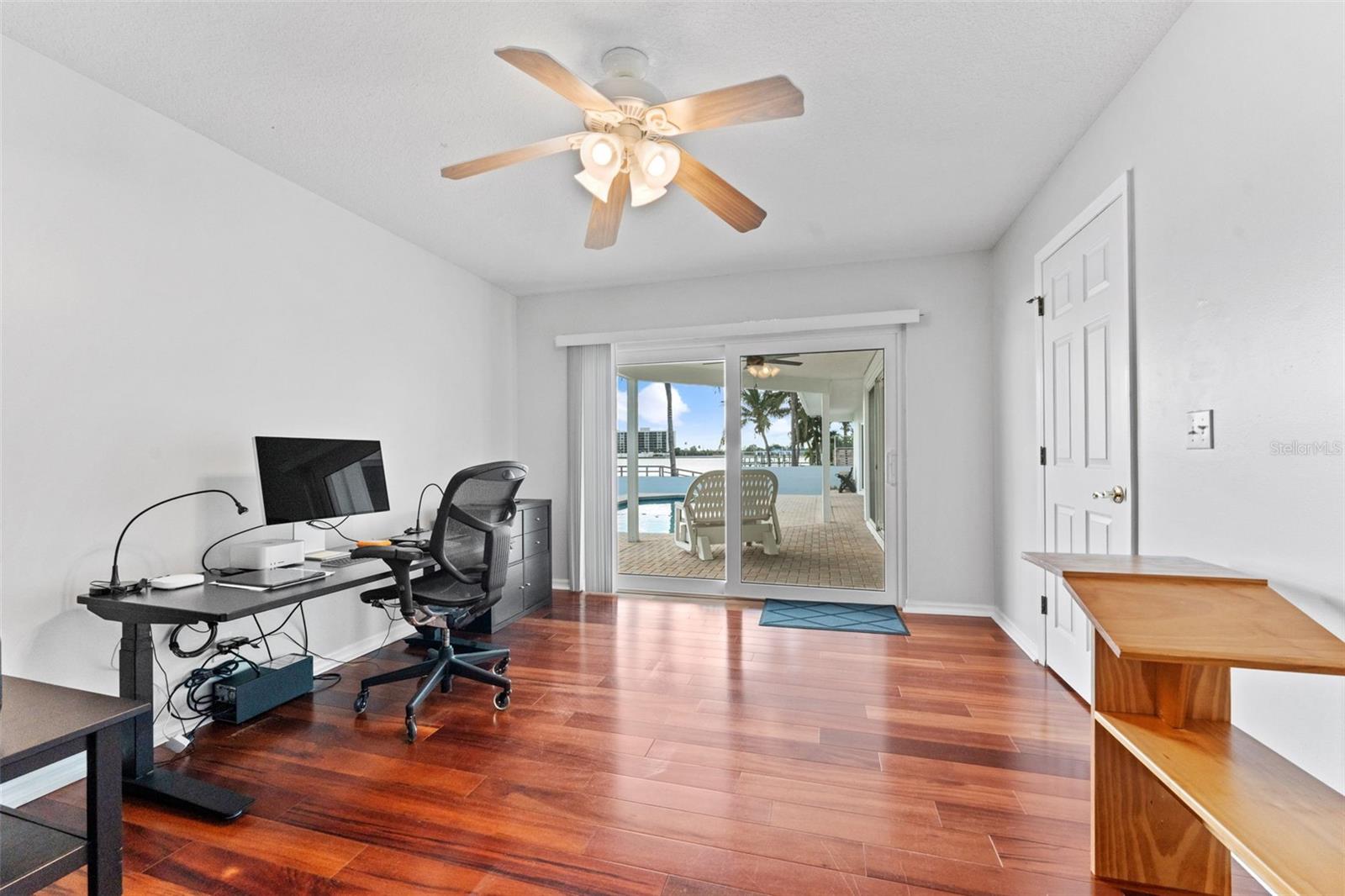 Bedroom 4 with sliding glass doors that open directly to the pool deck, blending indoor comfort with outdoor enjoyment.