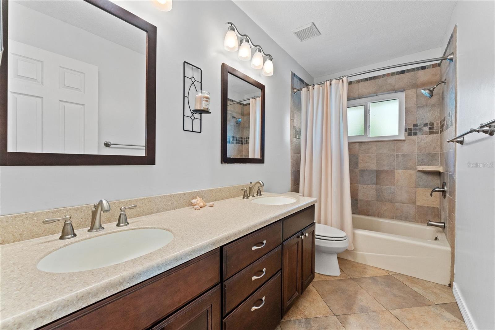Hall bathroom featuring a large double vanity, perfect for family use and morning routines.