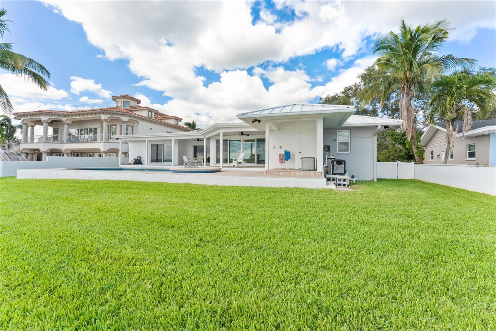 Spacious backyard with pool and patio, offering a picturesque view back toward the home.