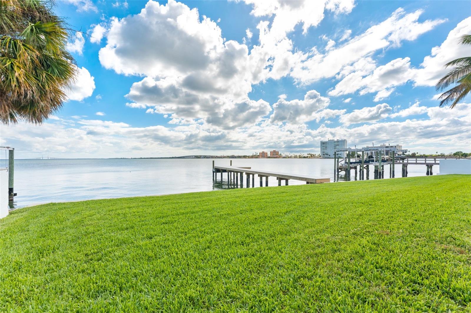 Backyard green space with views of the newly installed 2025 dock, ideal for outdoor enjoyment and waterfront access.