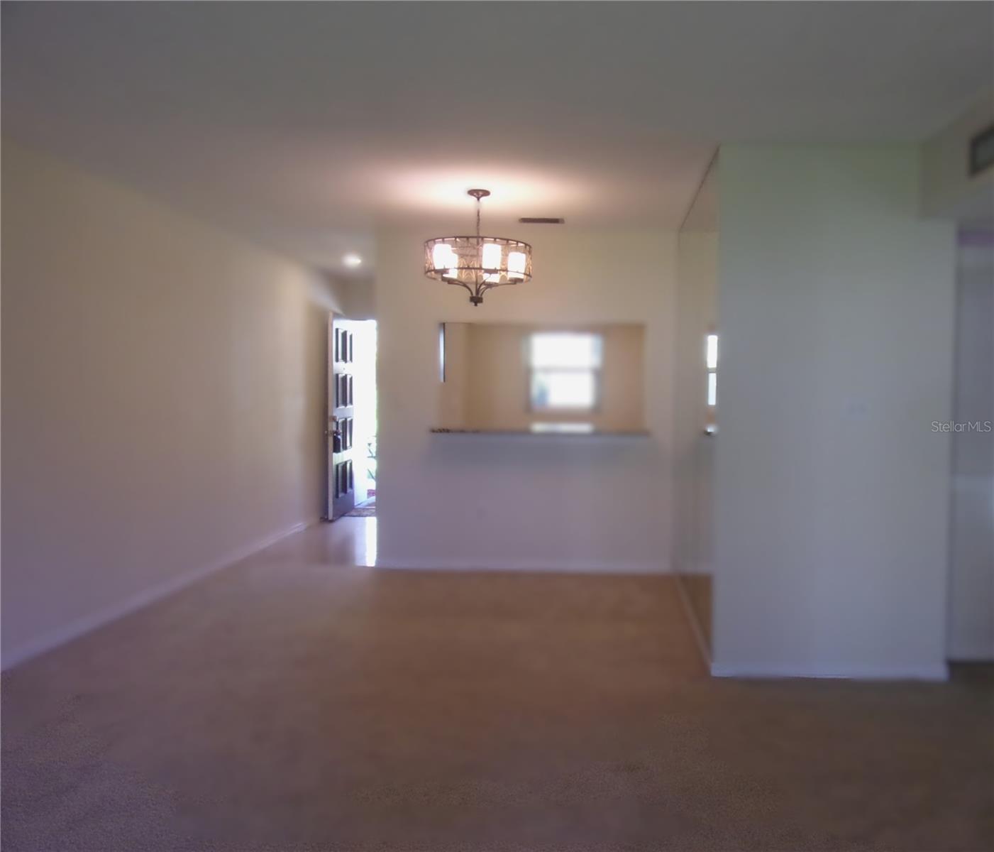 looking from patio into living room, dining and kitchen