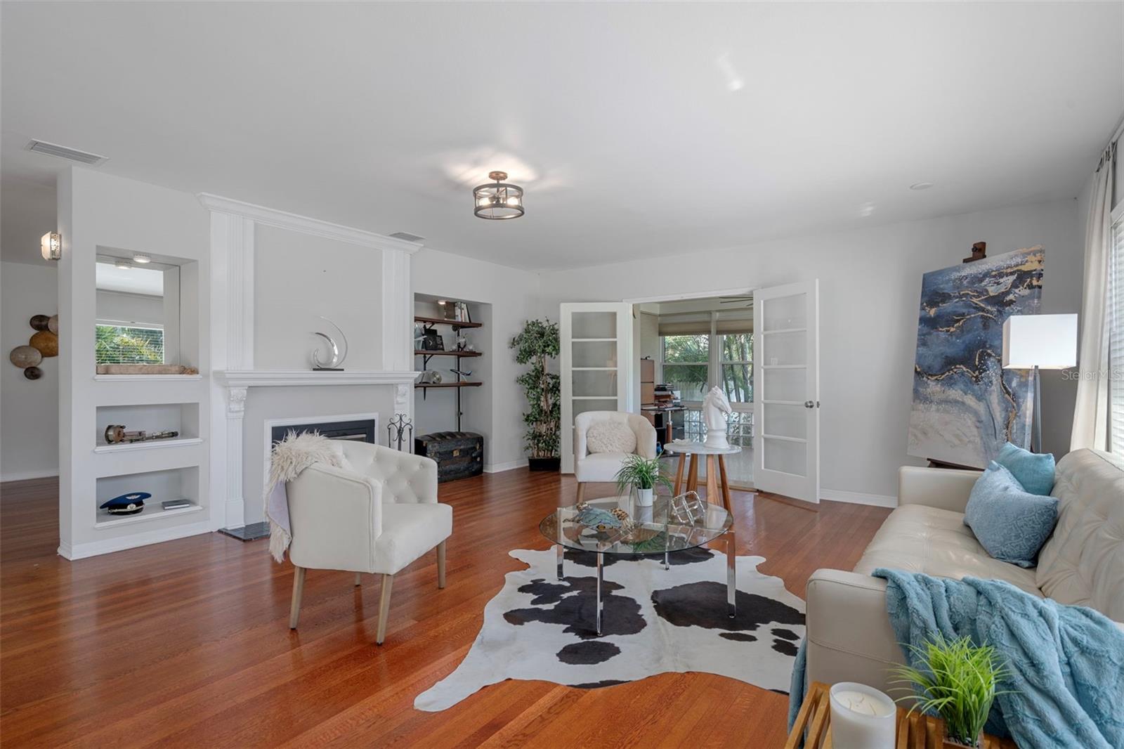 Spacious living room with curved plaster walls, hardwood floors, and a charming fireplace for cozy evenings.