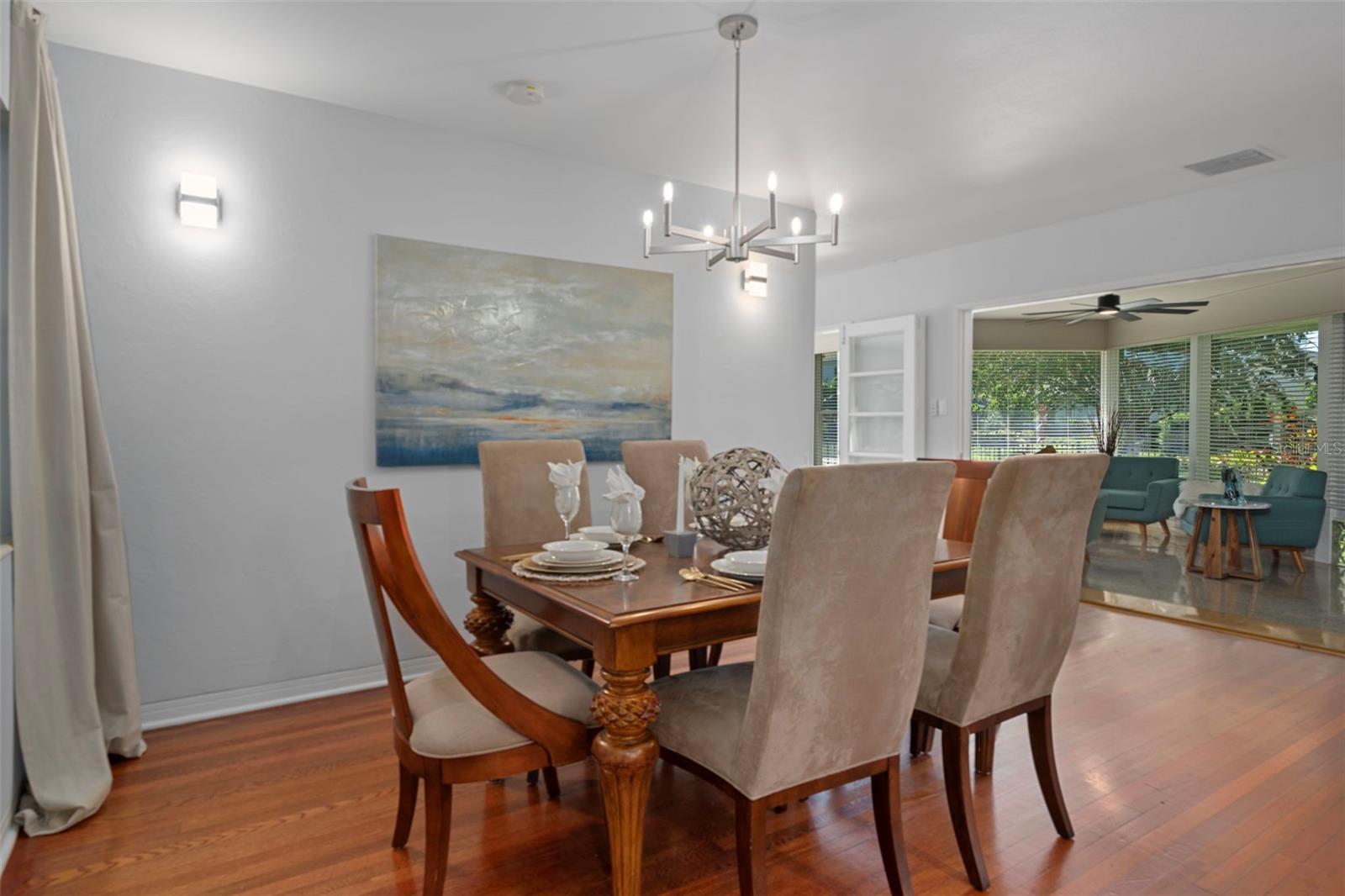 Dedicated dining room with hardwood floors and seamless flow into the sitting area.