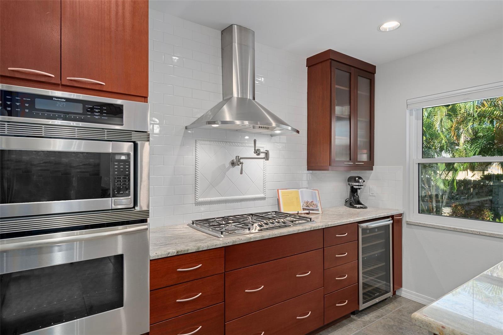 Updated kitchen featuring Thermador appliances, a five-burner gas cooktop, pot-filler, and wine refrigerator.