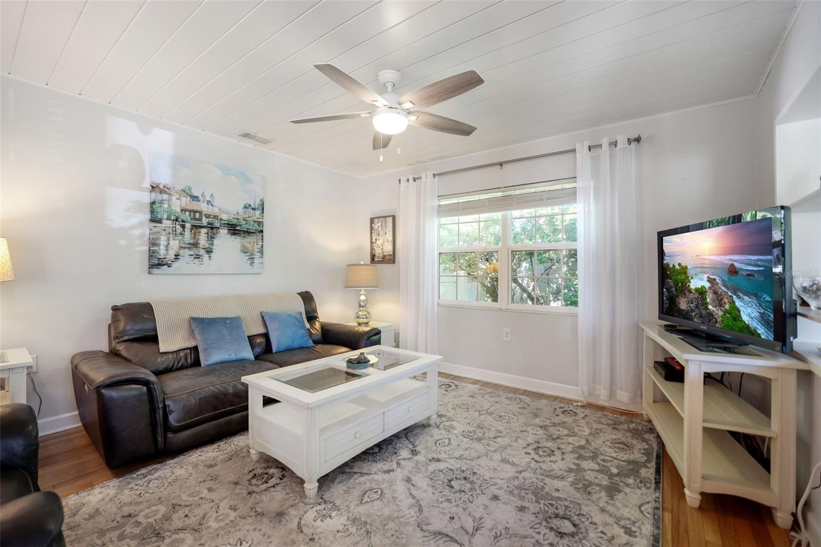 Living Room includes original hardwood floors and beadboard ceiling opens to the kitchen and entryway. If you like light and bright you won't be disappointed.