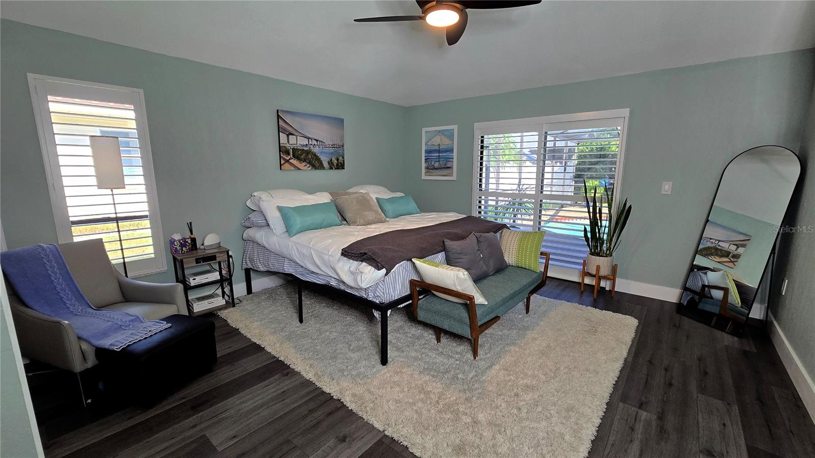 Primary Bedroom with access through the siding doors to the pool area in the back yard.  High Ceilings.