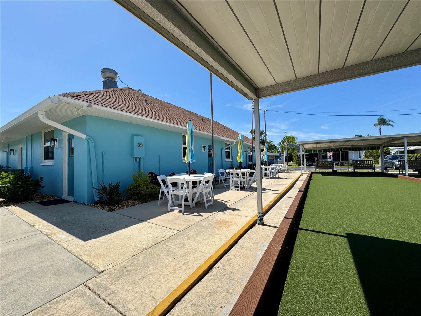 Westwind I clubhouse tables with umbrellas.