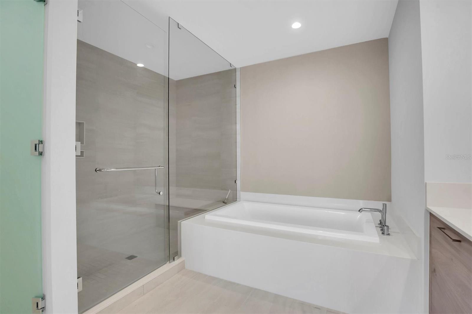 Primary ensuite offers a serene soaking tub, dual vanities, and a spacious shower.