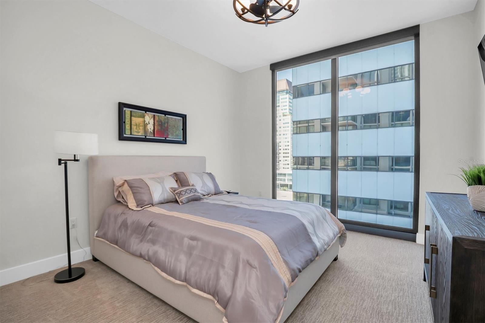 3rd ensuite bedroom features a floor-to-ceiling window with custom shades