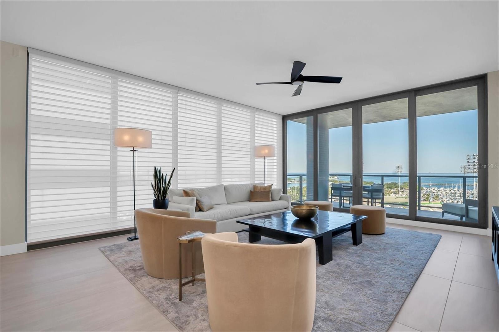 Custom shades, abundant natural light, and stunning Tampa Bay water views define the great room