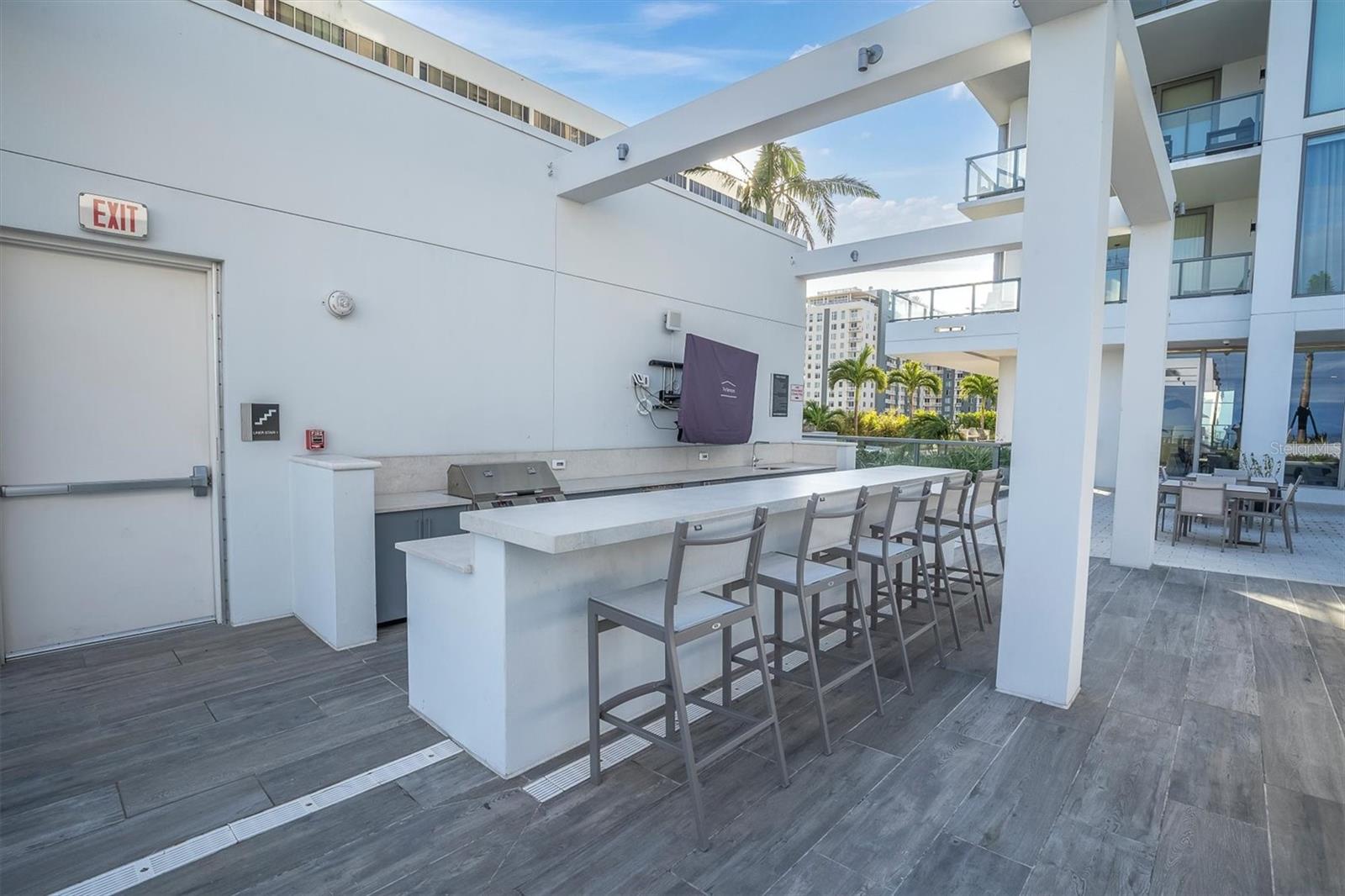Host with ease at the resort-style poolside grilling area featuring a TV for added entertainment