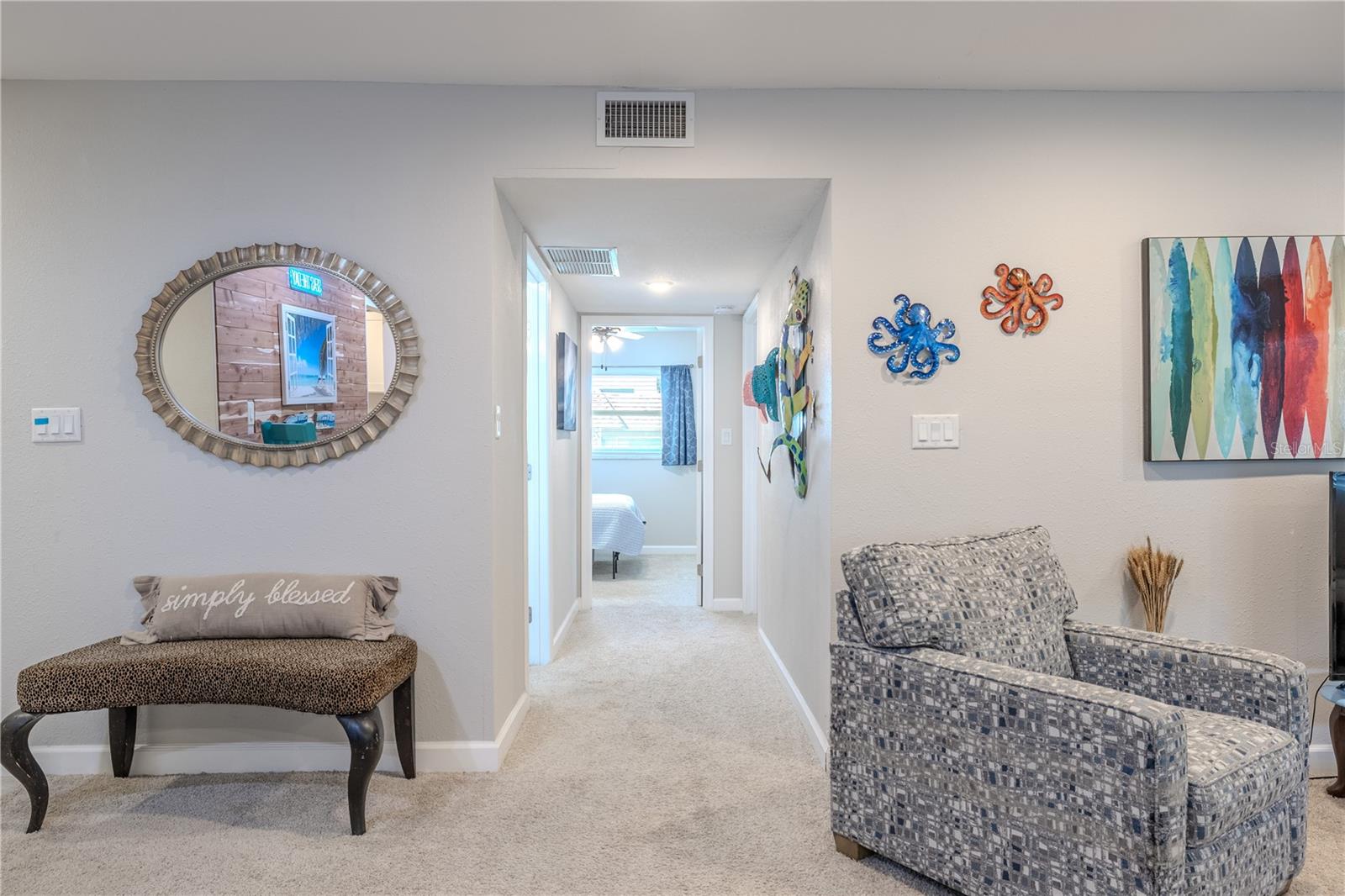 A clean and well-lit hallway leading to both bedrooms and bathrooms. The layout offers easy flow throughout the home and maintains a comfortable sense of openness.