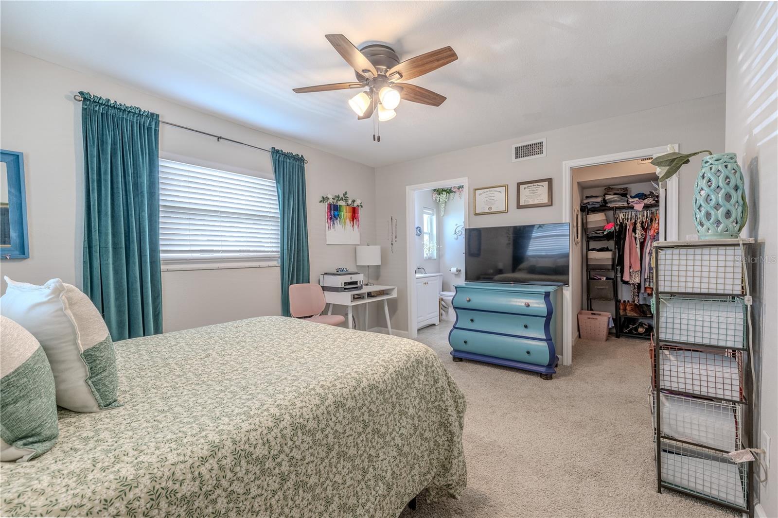 A broader perspective showing how the primary suite connects to the ensuite bath and walk-in closet, emphasizing both space and comfort.