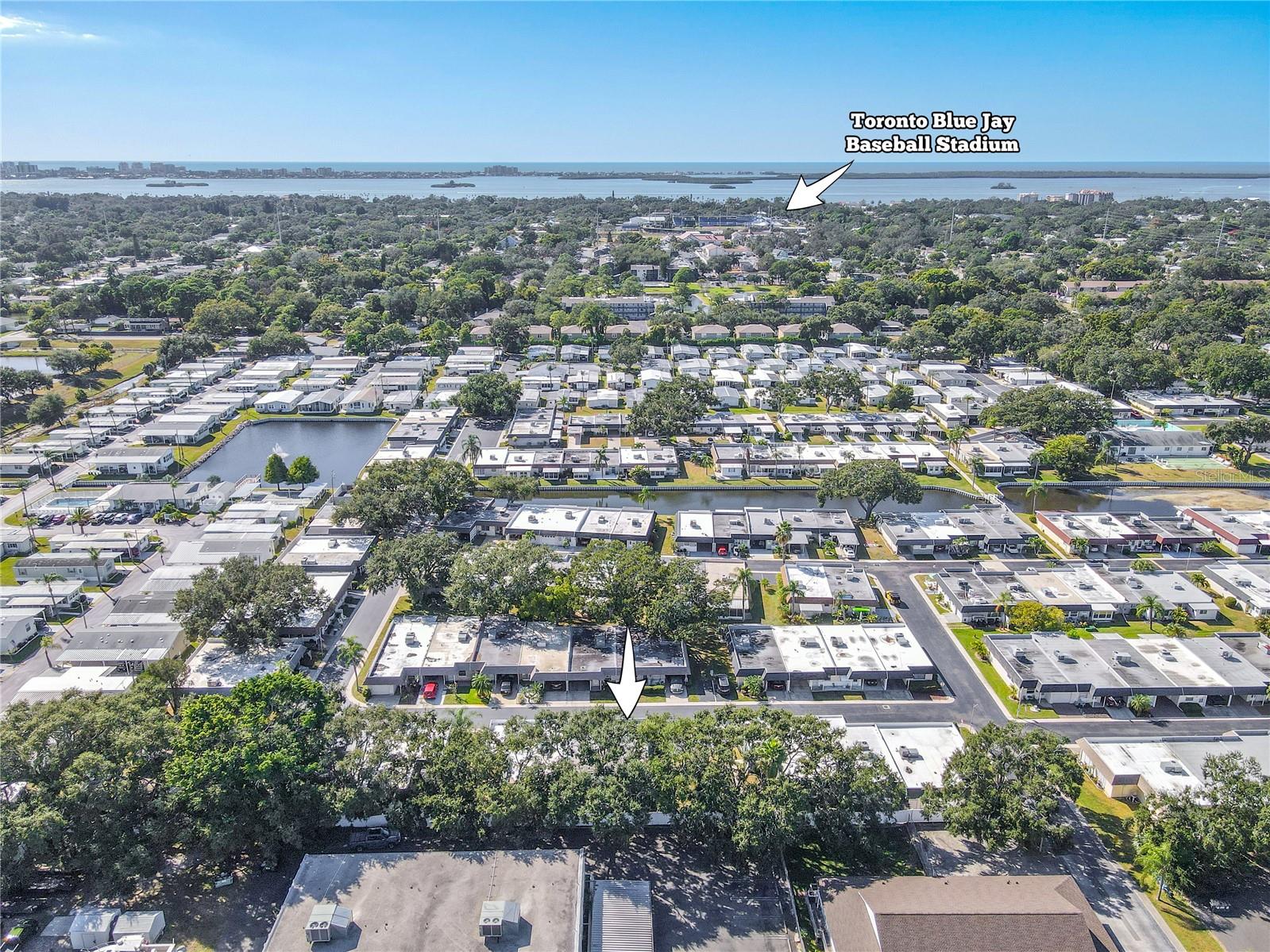 Expansive aerial view showcasing the beautifully kept Skye Loch Villas neighborhood. Manicured lawns, tree-lined streets, and open green spaces create a peaceful, walkable setting.