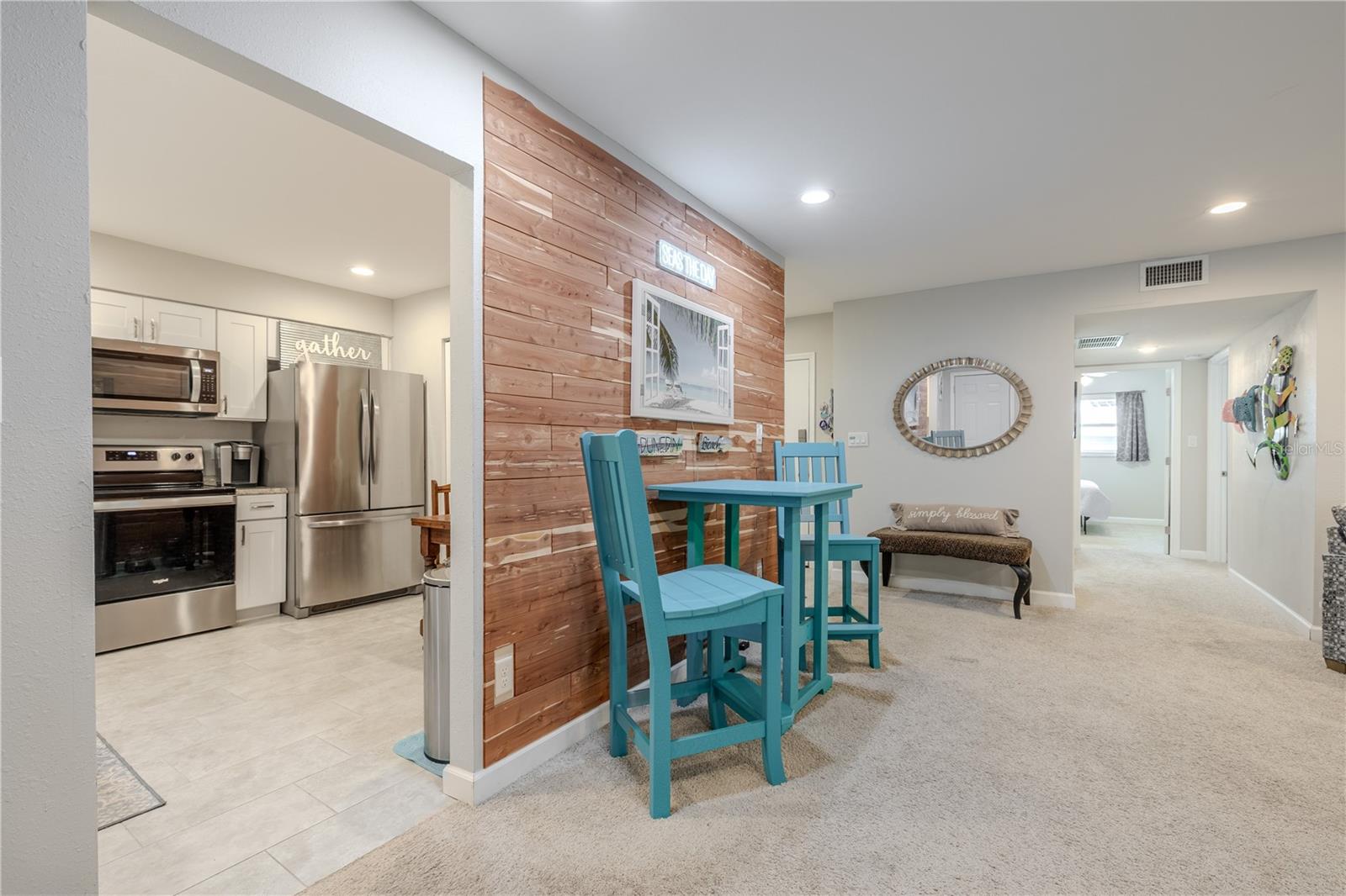 A view from the dining area toward the kitchen highlights the open flow and convenient pass-through design that keeps the space light and inviting.
