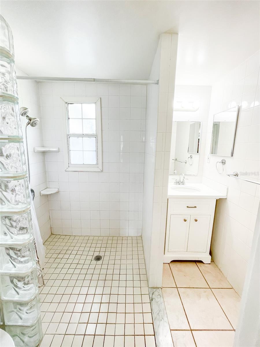 The bathroom has a large walk in shower that is wheelchair accessible.