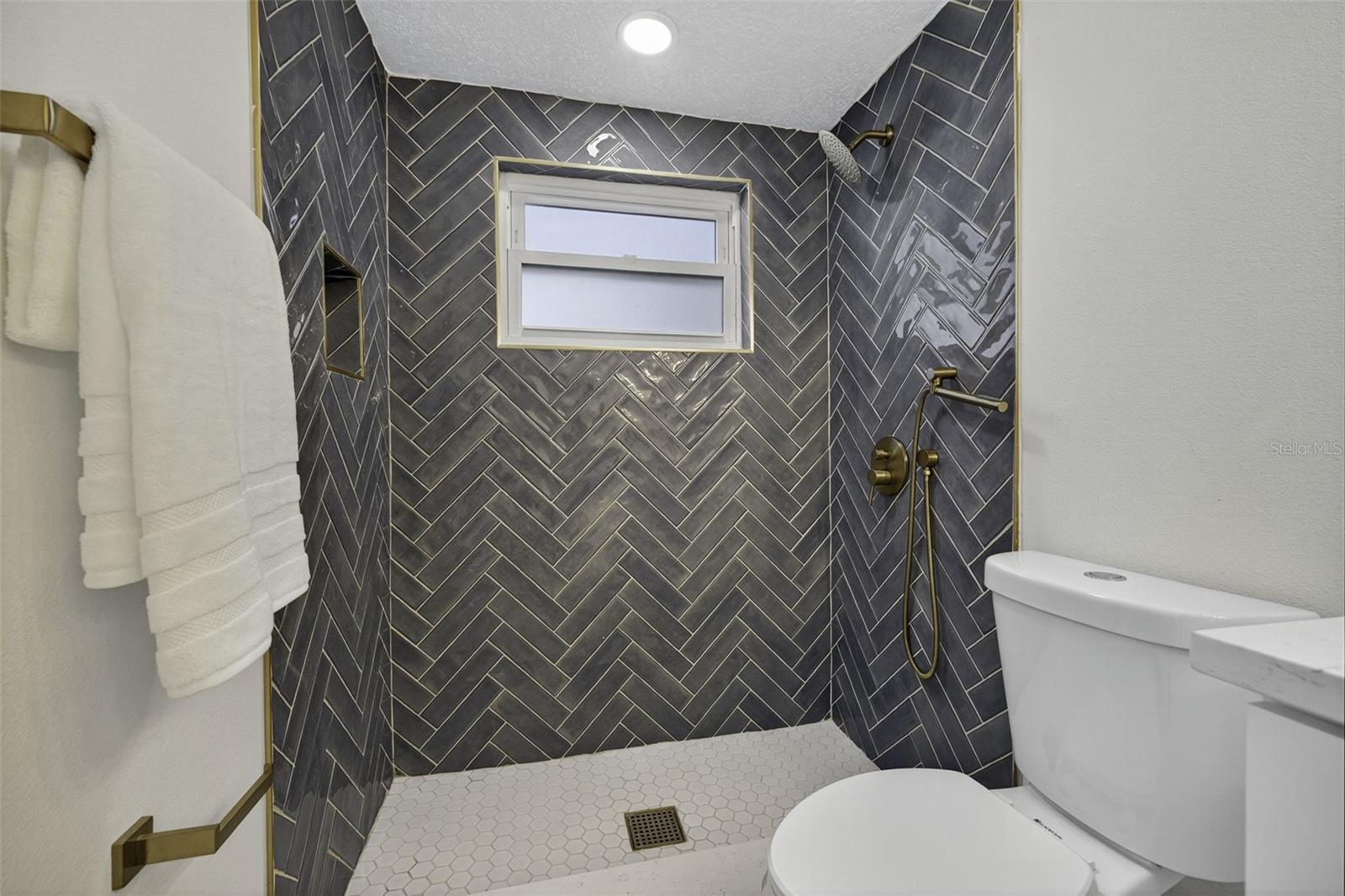 Ensuite Bathroom with Custom tiled shower, gold accents, and handheld sprayer