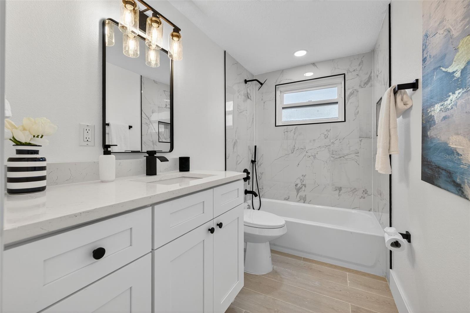 Bathroom 2 with bathtub custom tile, black accents and even includes a handheld shower!