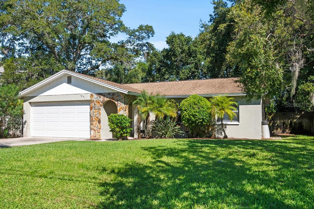 Exterior view, single-story ranch-style home with a well-manicured lawn.