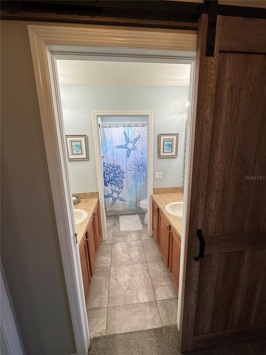 Hallway bathroom has 2 separate sinks and separate shower/toilet area