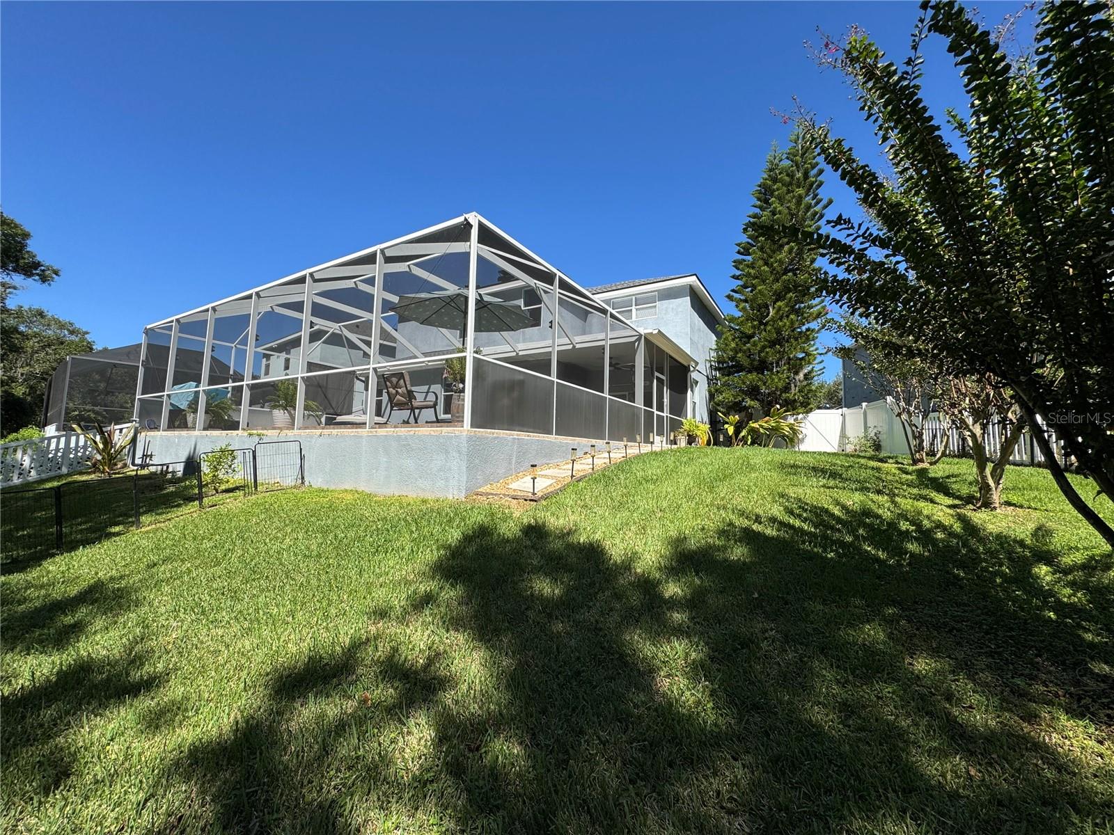 Backyard extends well beyond the screened pool area