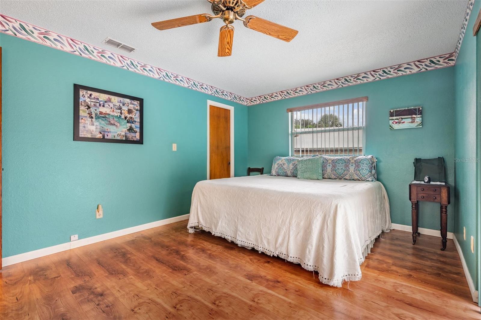 Primary bedroom with walk in closet and sliders to the pool
