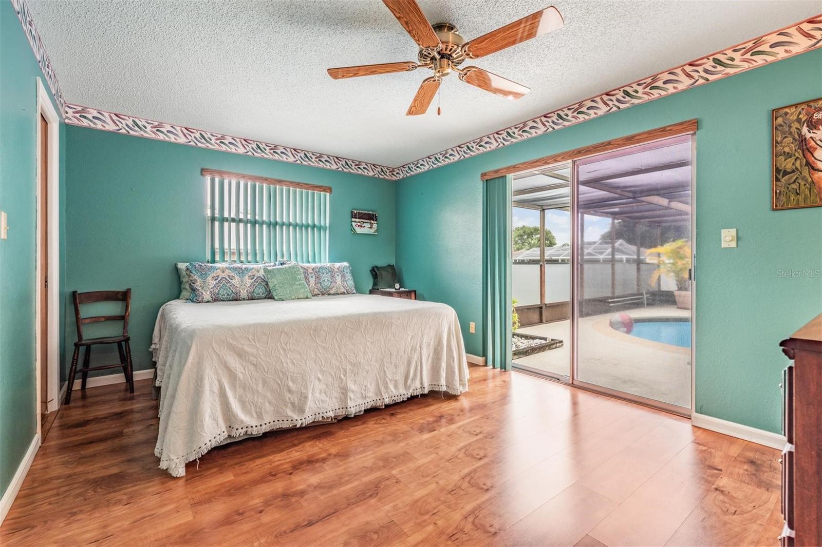 Primary bedroom with walk in closet and sliders to the pool