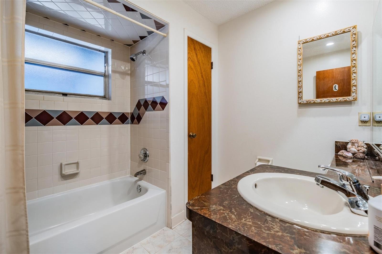 Shower/tub bathroom next to primary bedroom.