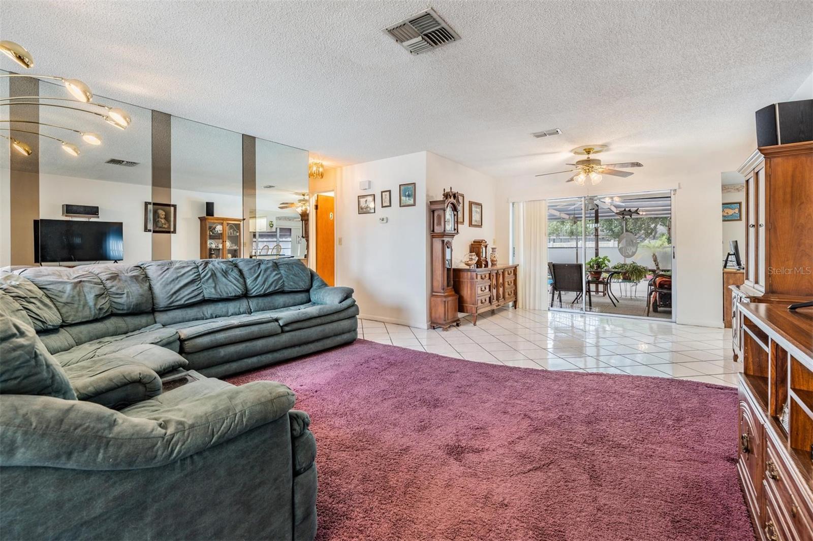Front door area has double coat closet doors in the foyer with bright window. Living Room, sliders to pool area