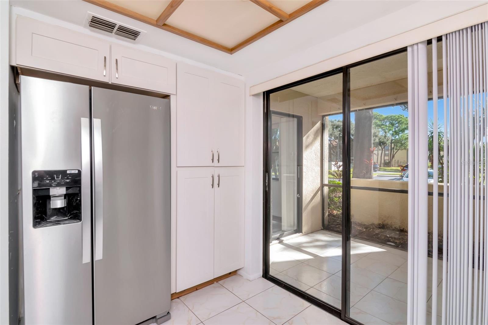 Bright kitchen opens to front tiled lanai