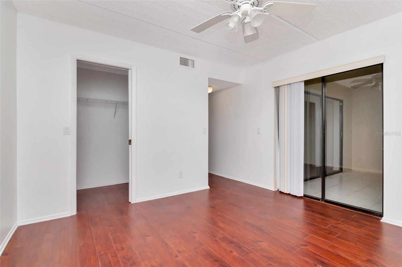 Primary bedroom with walk in closet and entrance to large back lanai
