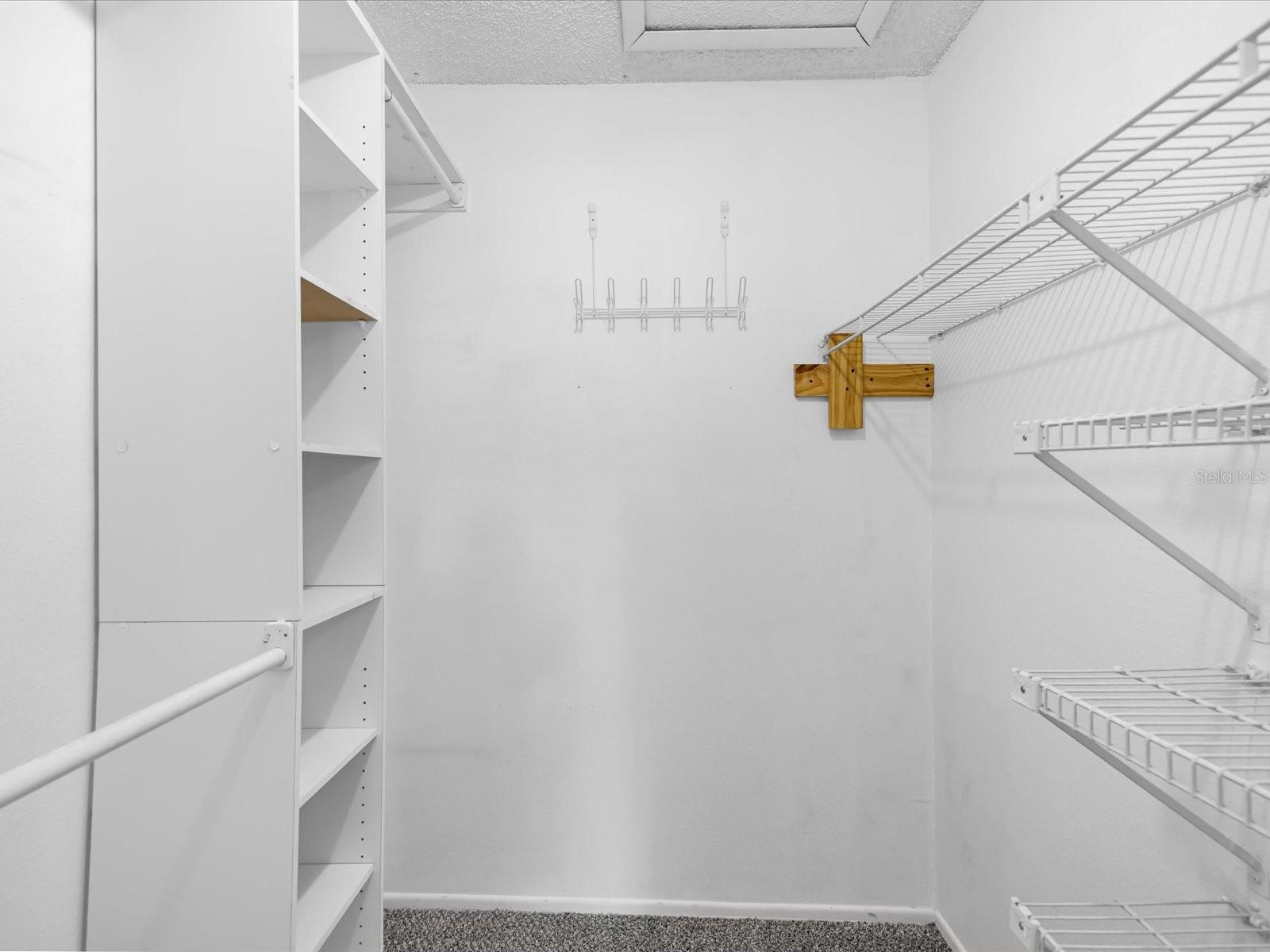 Primary walk in closet with custom built ins