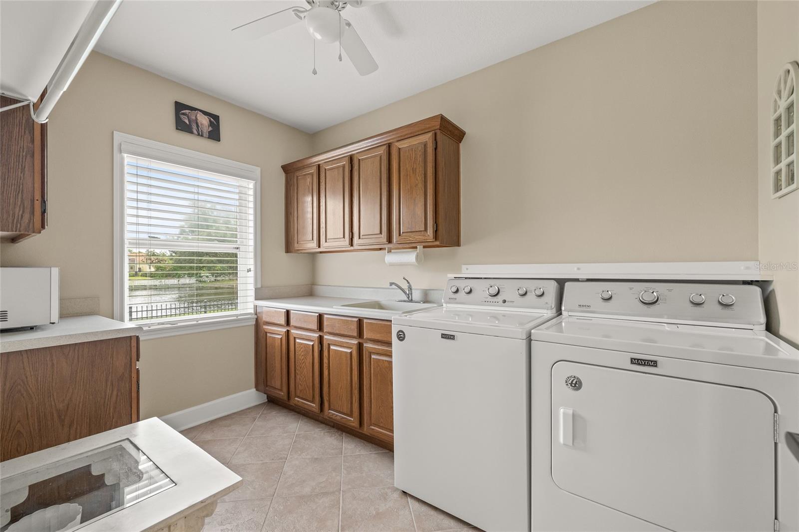 Large interior laundry room with a large storage closet to the right of the washer and dryer.
