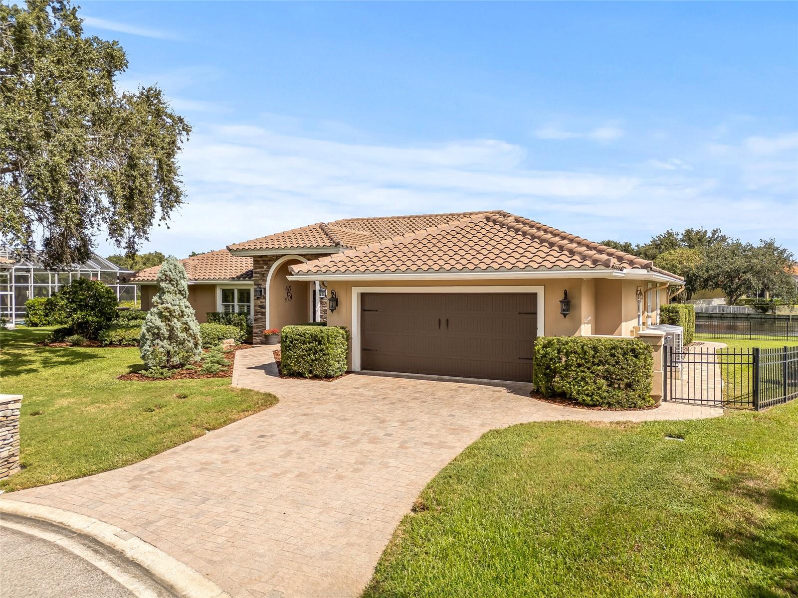 Gorgeous artisan pavers line the front driveway, sidewalk and pool patio.