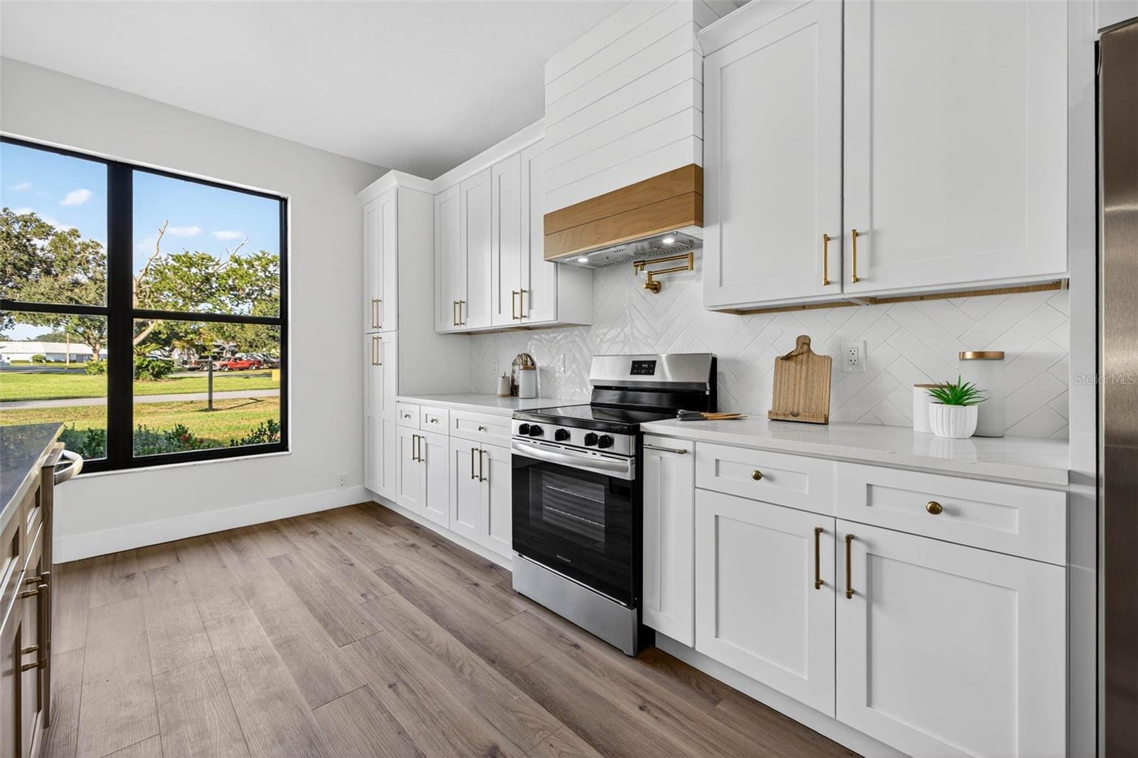 Beautiful Quartz Countertops, Custom Range Hood, and Stainless Steel New Appliances