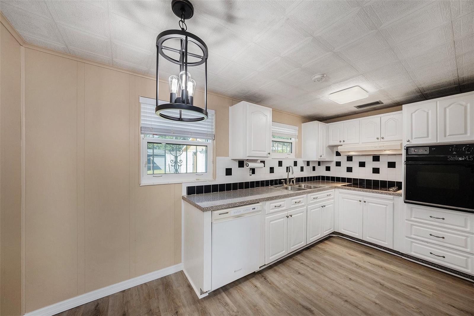 Prep your meals in this gorgeous kitchen, with a modern tile backsplash and updated light fixtures