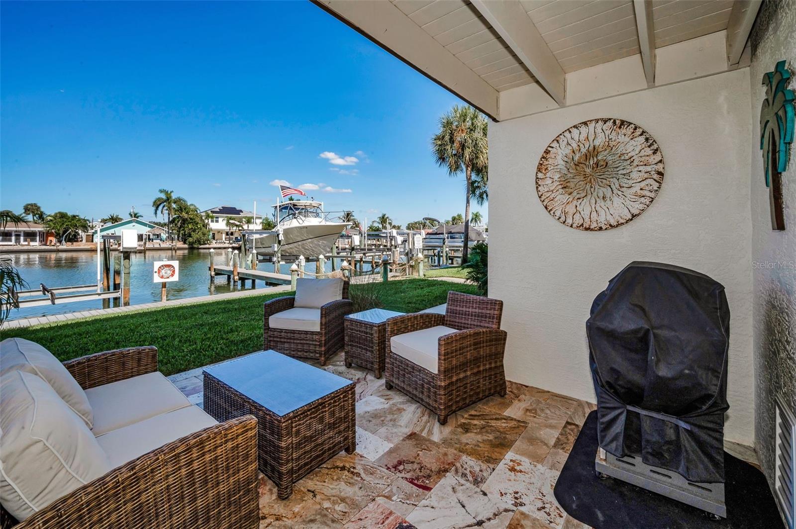 Custom waterfront patio with Travertine flooring on the Lower level