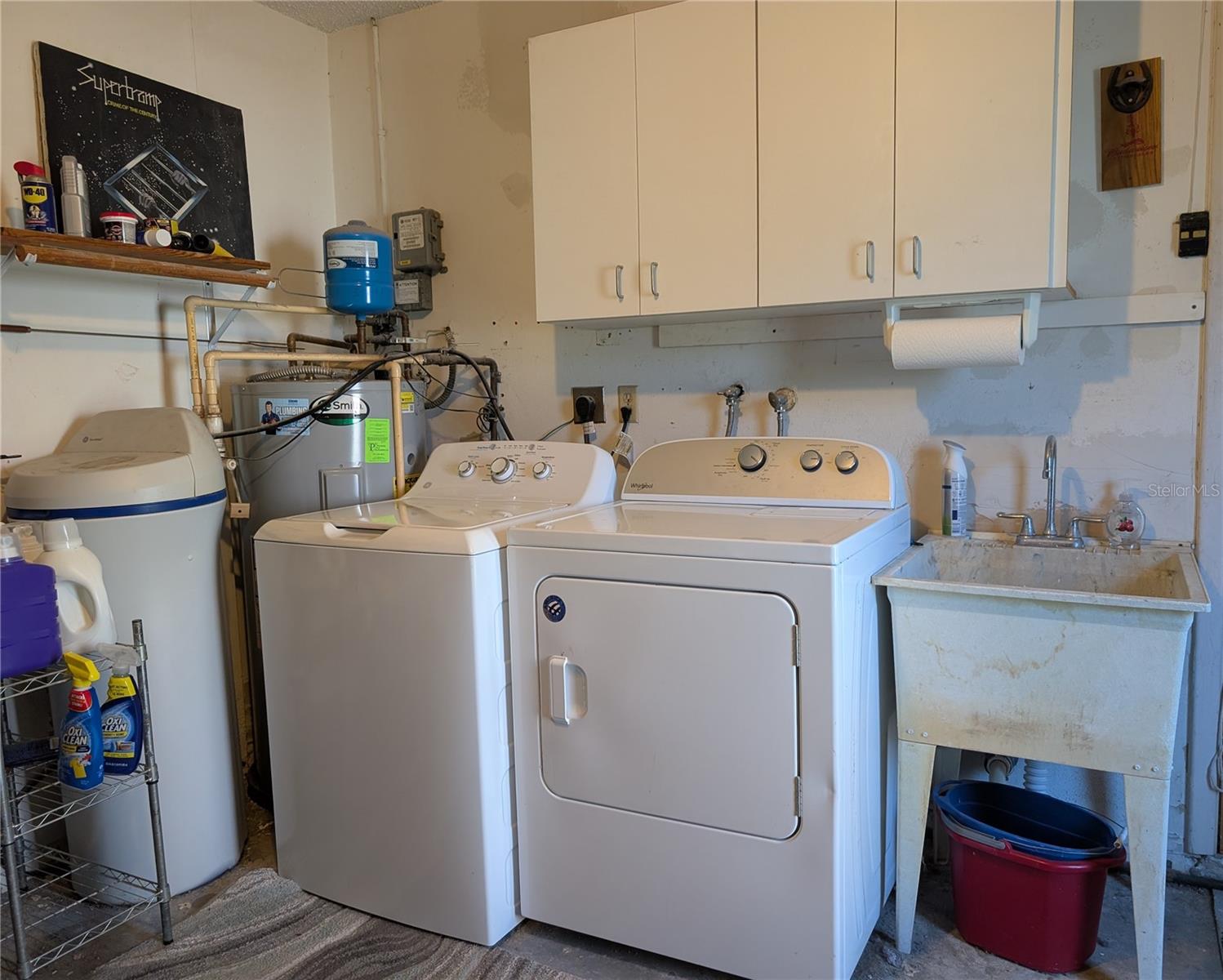 Laundry area in garage. Water softener, A.O. Smith water heater (2016), GE washer/WP Dryer and utility tub.