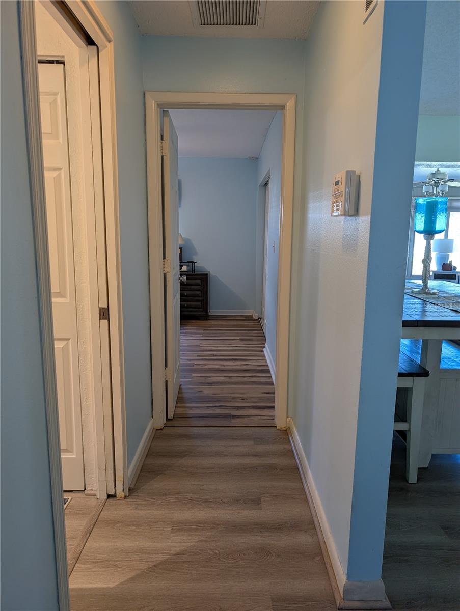 View from guest bedroom down hallway to Primary bedroom.  Main bathroom on left, living area on right.