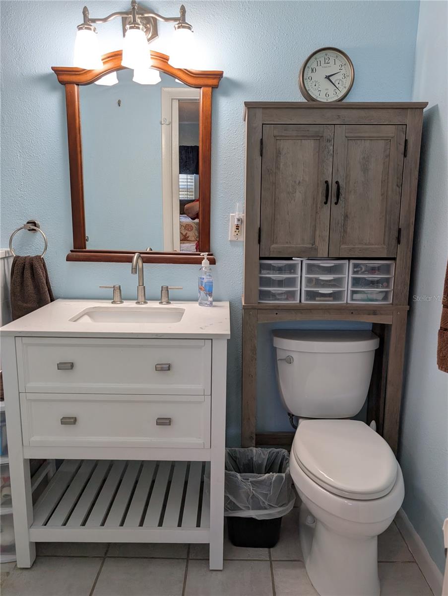 Updated ensuite bath is private.  Unique vanity, low flow commode, tile flooring, newer mirror and updated lighting.