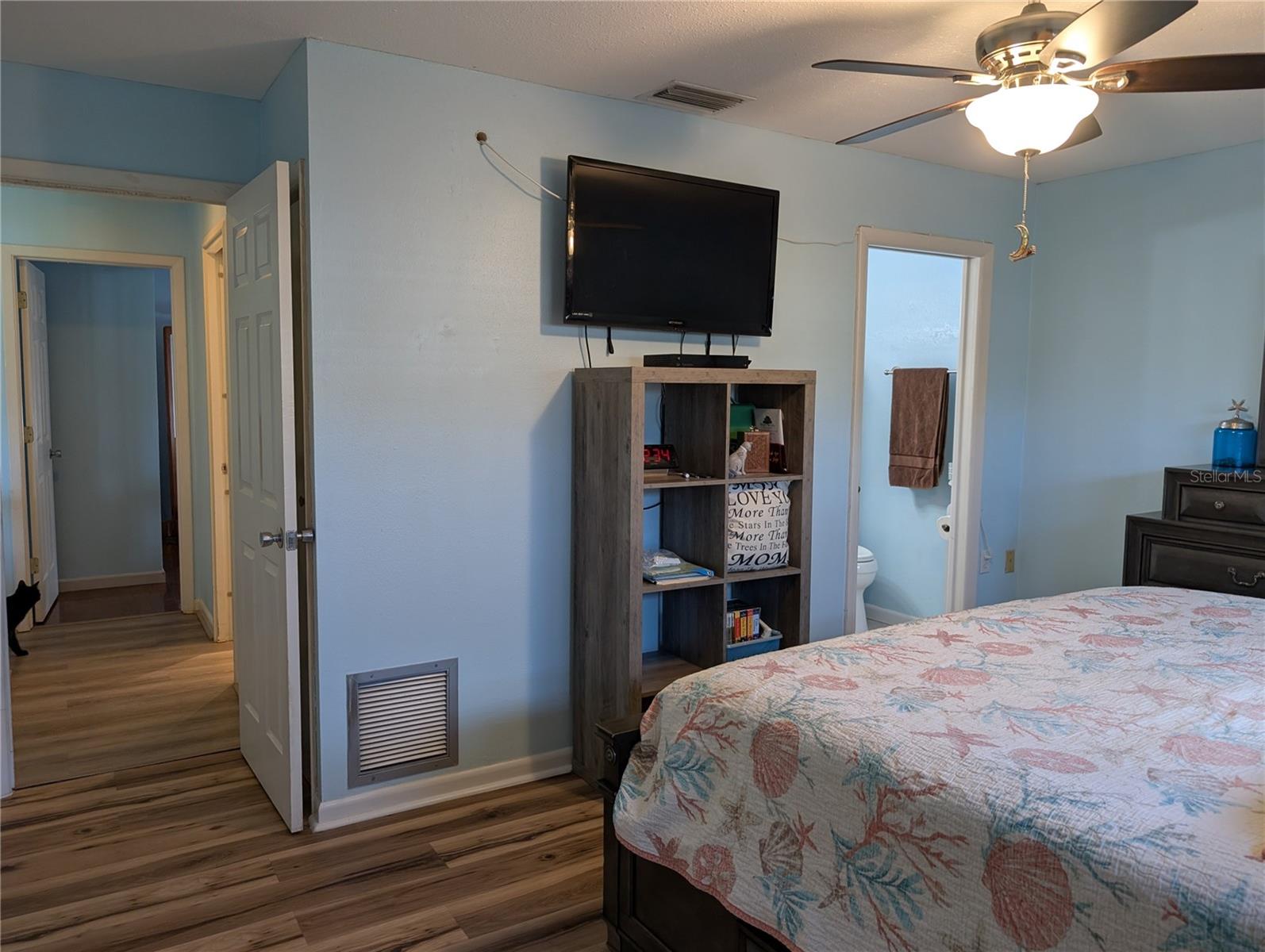 View from primary bedroom down hallway to guest bedroom.  Main bath on right, living area on left.