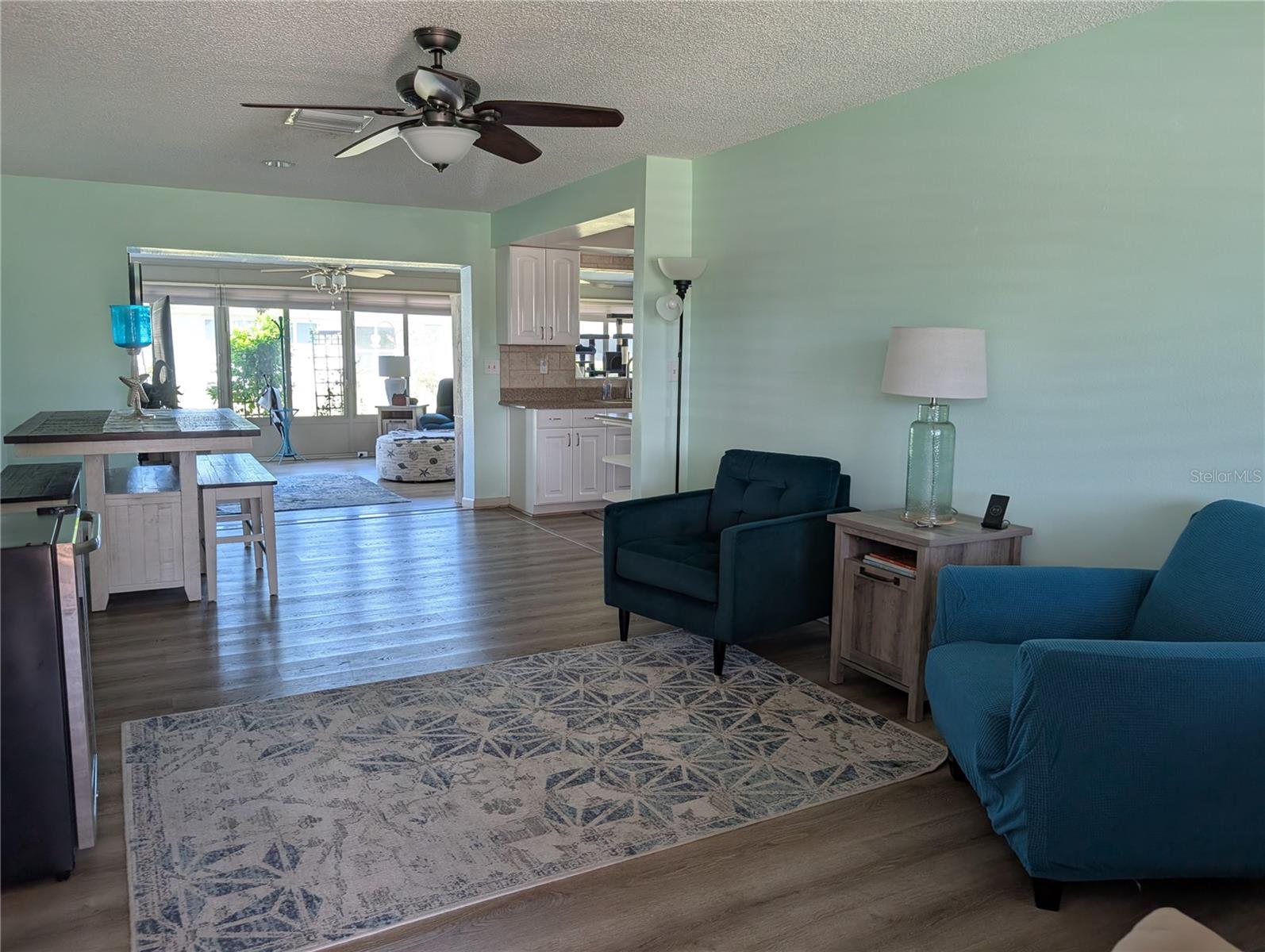 View from front entry. A fresh splash of tropical calmness.  Stylish vinyl flooring throughout living areas and kitchen.  Updated ceiling fans in every area.