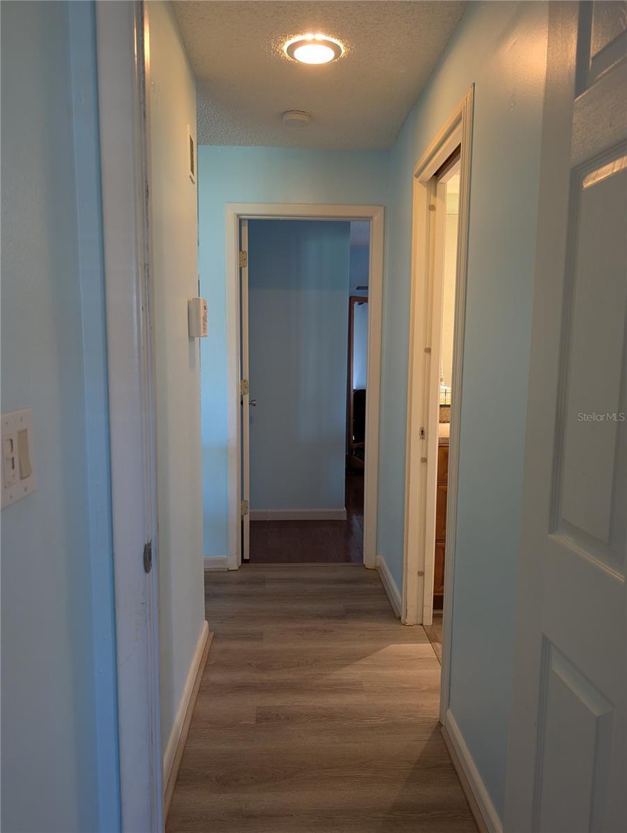 View from Primary bedroom to Guest bedroom.  Main bath on right, entry to living area on left.